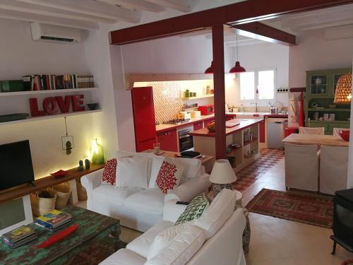 Il comprend un salon avec des canapés blancs et une cuisine. dans l'établissement Casa Bitxu, à Port Mahon