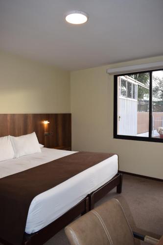 a bedroom with a large bed and a window at Hotel Villa del Carmen in Arequipa