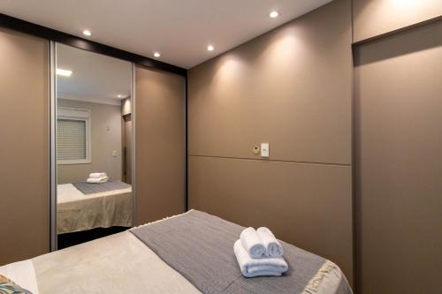 a bedroom with two towels on a bed and a mirror at Metropolitan Stay 21610, Piscina, Academia, Vaga in Guarulhos