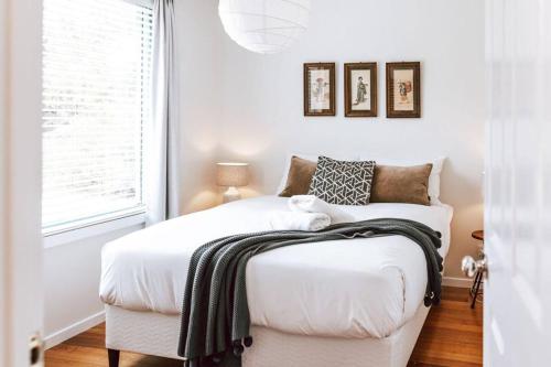 a bedroom with a white bed and a window at Mountain View - Sealladh Beinne in Falmouth