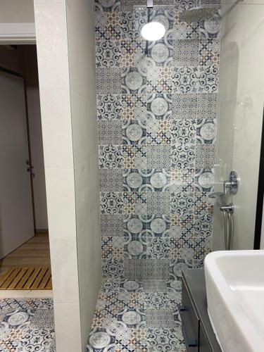 a bathroom with a shower with a tile wall at Al Posto Giusto apartments in Igalo