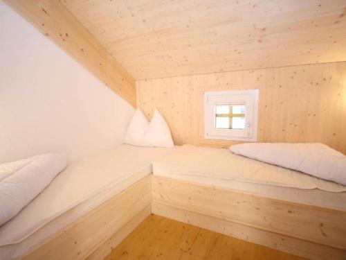 two beds in a small room with a window at Wolkenheim in Hohentauern