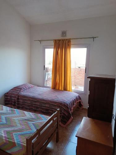 En eller flere senge i et værelse på Departamento Barrio Escuela