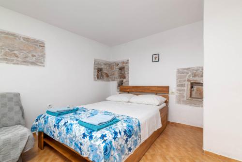a white bedroom with a bed with a blue blanket at Studio Basanija 7148a in Savudrija