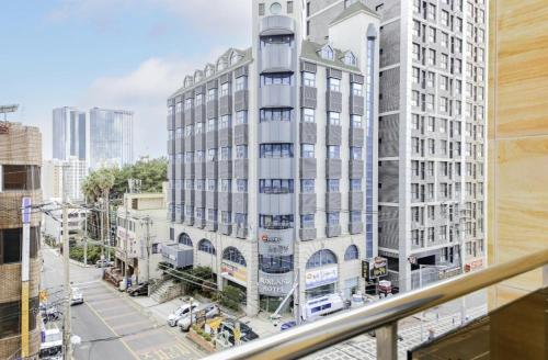 a tall white building on a city street at Sunland Hotel Jeju in Yŏn-dong