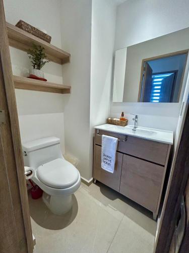 a bathroom with a white toilet and a sink at Depa Beara 107 nuevo moderno in Sandovales