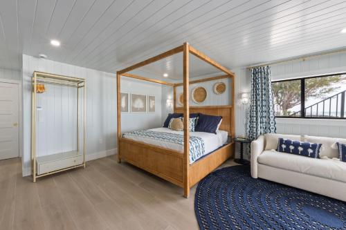 a bedroom with a canopy bed and a couch at Seabreeze at Anna Maria Island Inn in Bradenton Beach