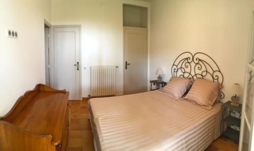 - une chambre avec un grand lit blanc et un banc dans l'établissement Villa Defendum, à Vallauris