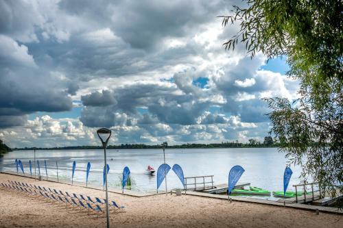 a group of boats sitting on the shore of a lake at Hotel Warszawianka in Jachranka