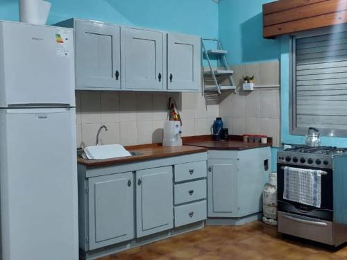 a kitchen with white cabinets and a white refrigerator at RINCÓN Del DESCANSO in Oberá