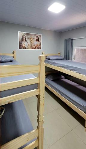 a room with three bunk beds in it at Aliança da Fé in Cachoeira Paulista