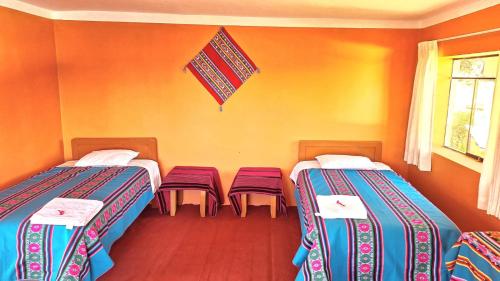 a room with two beds and a flag on the wall at AMANTANI LODGE LoveLand in Amantani
