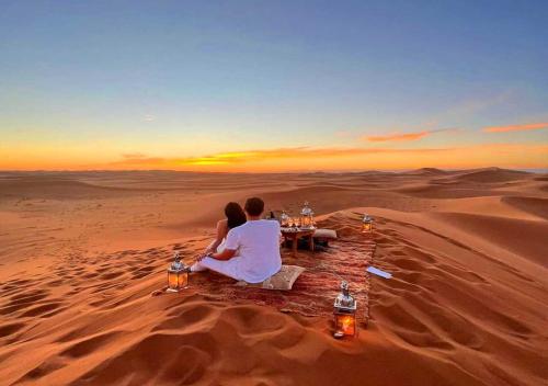 a couple sitting at a table in the desert at Berber Luxurious Camp in Merzouga