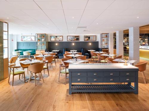 a dining room with tables and chairs in a restaurant at Novotel York Centre in York