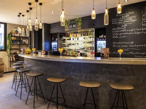 a bar in a restaurant with stools and a counter at ibis Paris Alesia Montparnasse in Paris