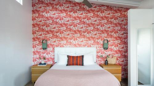 a bedroom with a bed and a red wall at 3 Private 1 Bedroom Units at The Wesley Sleeps 12 in Palm Springs