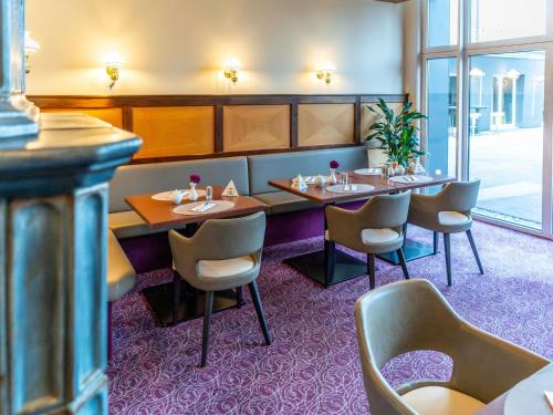 a restaurant with tables and chairs in a room at Mercure Salzburg City in Salzburg