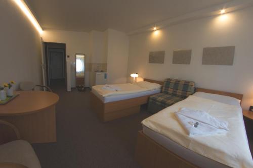 a hotel room with two beds and a chair at Hotel Wolf in Prague