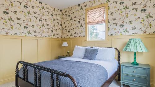 a bedroom with a bed and a window with floral wallpaper at Spacious 4BR Home w Fireplace Work Space Backyard Dining in San Diego