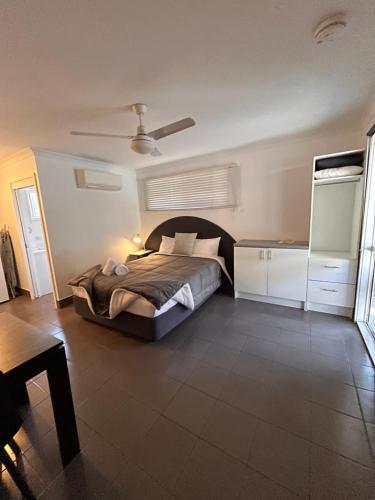 a bedroom with a bed and a ceiling fan at Agnes Palms Motel in Agnes Water