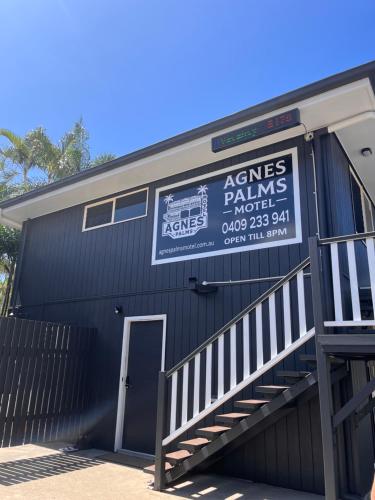 a black building with a sign on the side of it at Agnes Palms Motel in Agnes Water