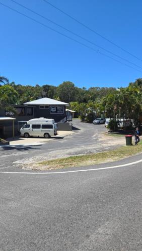a parking lot with a white van parked in front of a building at Agnes Palms Motel in Agnes Water