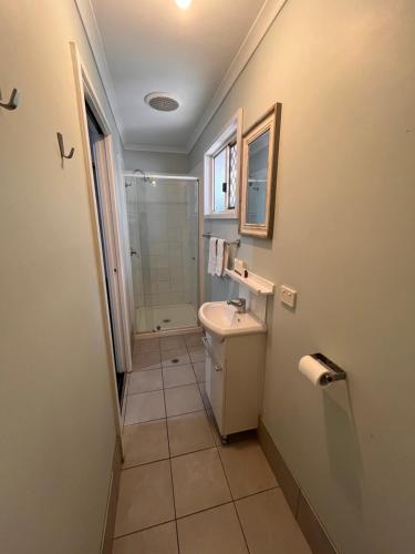 a bathroom with a sink and a shower at Agnes Palms Motel in Agnes Water