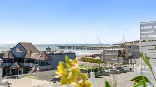 a view of the beach from the balcony of a beach house at The Cayucan Bungalows by AvantStay Pet-Friendly Getaway Steps from Cayucos State Beach in Cayucos