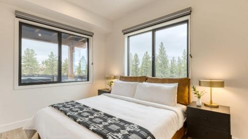 a bedroom with a large bed and two windows at 2 Units Minutes to Old Bend Deck Hot Tub 1216 Skyline Ranch by AvantStay in Bend
