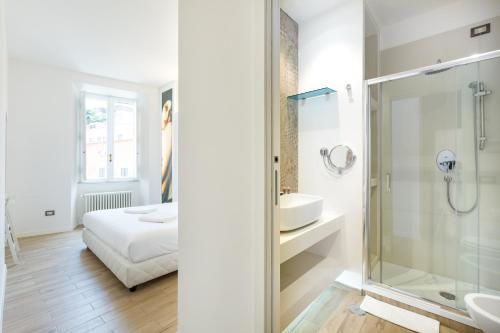 a bathroom with a shower and a sink and a bedroom at Deluxe Ripetta 41 in Rome
