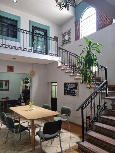 a table and chairs in a room with a staircase at Suites Chingón in Guadalajara