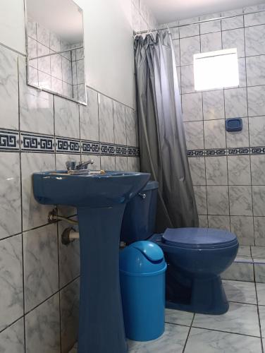 a bathroom with a blue toilet and a sink at Hotel Keros in Chivay