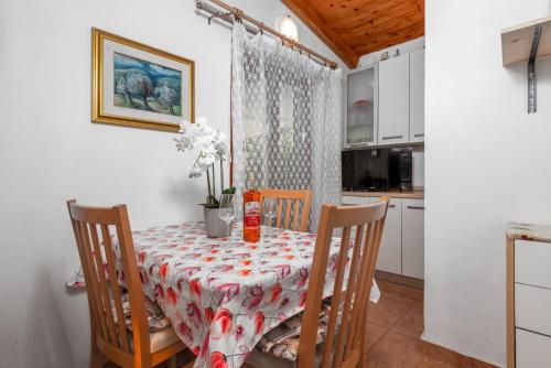 een eetkamer met een tafel en stoelen en een keuken bij Holiday house with a parking space Babici, Umag - 13795 in Umag