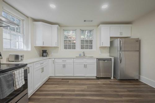 a kitchen with white cabinets and a stainless steel refrigerator at The Complex on Bobbin Mills in Athens