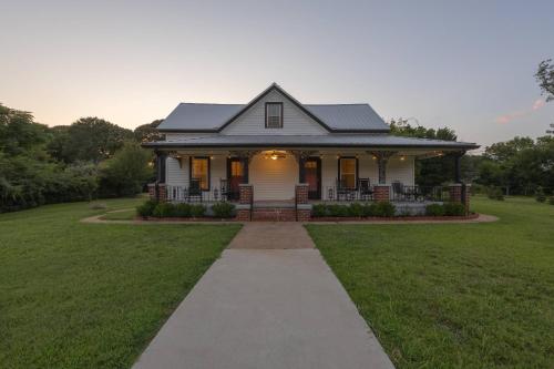 a white house with a pathway in front of it at The Bulldog Farmhouse - 100 year old home in Athens