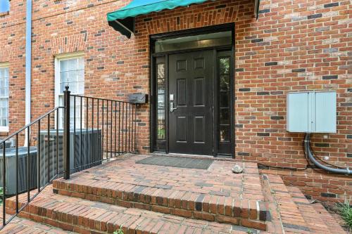 a black door on a brick building with a brick sidewalk at NEW LISTING The Classic City Collection - 3 Separate Units in Athens