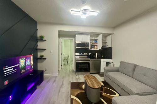 a living room with a couch and a tv at Cozy 2BR Retreat - 10 Mins to WEM - Free Parking & WiFi in Edmonton