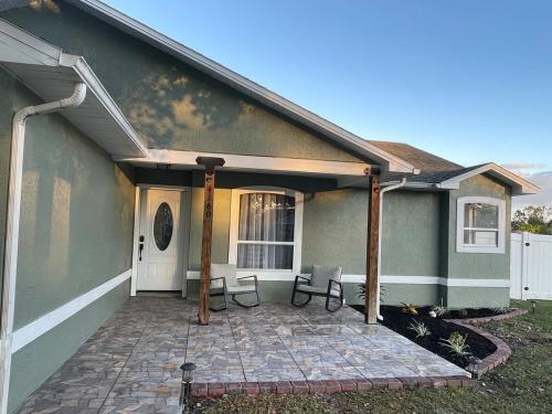 a house with a patio with two chairs on it at Modern Escape in Kissimmee in Kissimmee