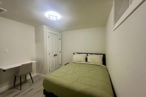 a small bedroom with a bed and a desk at Cozy 2BR Retreat - 10 Mins to WEM - Free Parking & WiFi in Edmonton