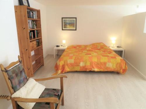 a bedroom with a bed and a chair and a book shelf at Hiltrup Stübchen in Amelsbüren