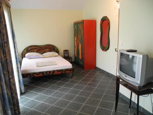 1 dormitorio con 1 cama y TV en una habitación en Apartments Magic Time, en Podstrana