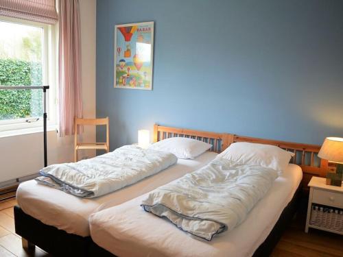 two twin beds in a room with a window at with large, fenced garden DL108 in Domburg