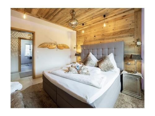 ボレンドルフにあるOne-bedroom apartmentの木製の壁のベッドルーム1室(白い大型ベッド1台付)
