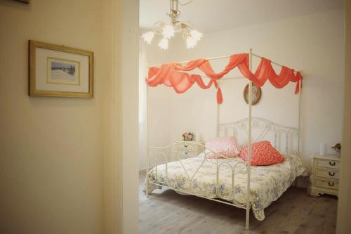 1 dormitorio con 1 cama con dosel en La Casa nel Bosco, en Civitella in Val di Chiana
