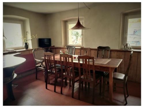 Un comedor con mesa y sillas de madera. en old shepherd's house, en Mainleus