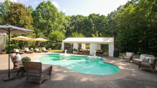 a swimming pool with chairs and a gazebo at 35 Acre Estate w Pool Spa Wine Cellar Gym Near Golf Club La Pearla Ranch by AvantStay in Kingston Springs