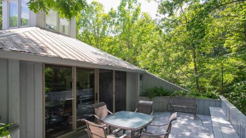 a patio with a table and chairs on a balcony at 35 Acre Estate w Pool Spa Wine Cellar Gym Near Golf Club La Pearla Ranch by AvantStay in Kingston Springs