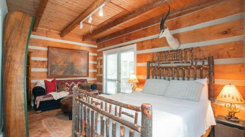 a bedroom with a bed in a room with wooden walls at 35 Acre Estate w Pool Spa Wine Cellar Gym Near Golf Club La Pearla Ranch by AvantStay in Kingston Springs