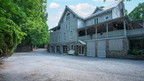 a large gray house with a large driveway at 35 Acre Estate w Pool Spa Wine Cellar Gym Near Golf Club La Pearla Ranch by AvantStay in Kingston Springs