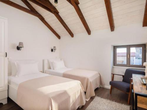 a bedroom with two beds and a desk and a chair at Villa Casa Di Pietra in Rupići